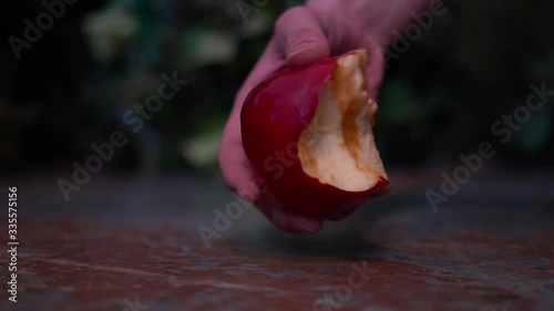 a hand picked up a red Apple from the floor