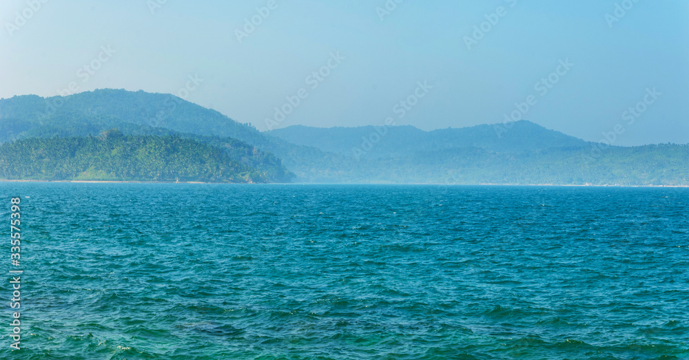 Tree-covered hills by the ocean. Tree-covered hills by the ocean.
