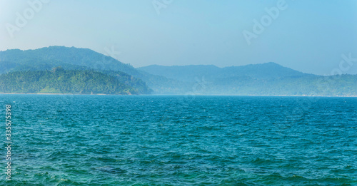 Tree-covered hills by the ocean.