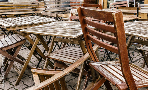 Wooden chairs and tables stored, locked and chained early morning © BlokPhoto