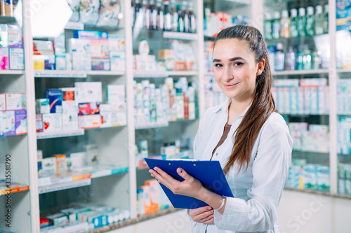 pharmacist chemist woman working in pharmacy drugstore with tablet.