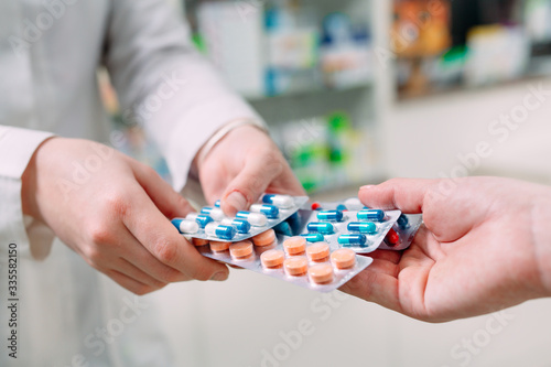 Close up of a girl hands buying pills in a pharmacy.
