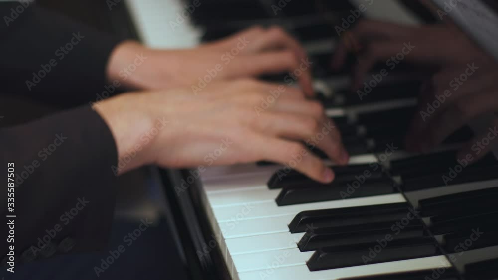 Adult man plays classical composition on a piano in a luxury hotel restaurant.