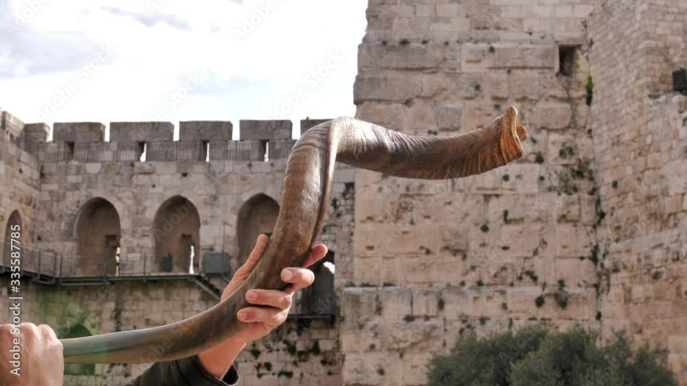 Jewish men blowing shofar in Jerusalem. Israel. The ancient walls of the old town, the City of David is on the background.