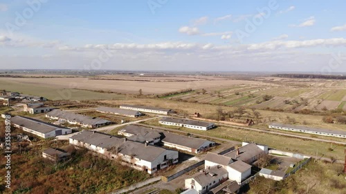 Bird's eye view of abandoned stables of a bankrupt collective farm. Aerial drone 4k, zoom in with pan photo