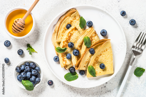 Crepes with blueberries at white table. photo