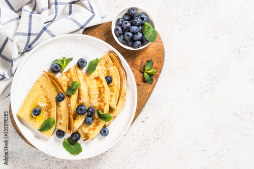 Crepes with blueberries at white table. photo