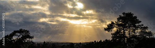 The sun's rays shine through the clouds. Cloudy skies. Sunset landscape.