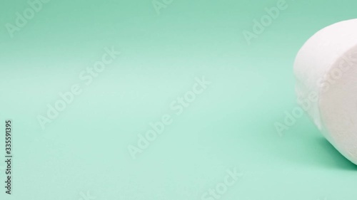 The toilet paper roll is rolling on a green background.