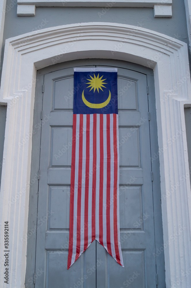 Fototapeta premium Malaysia flag banner at door of building.