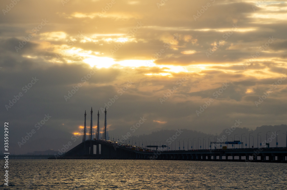 Golden cloud sunrise over Penang Bridge.