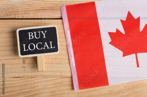 goods and services concept - canadian country's flag, blackboard with text Buy local