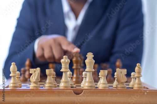 Businessman hand moving of playing chess strategy