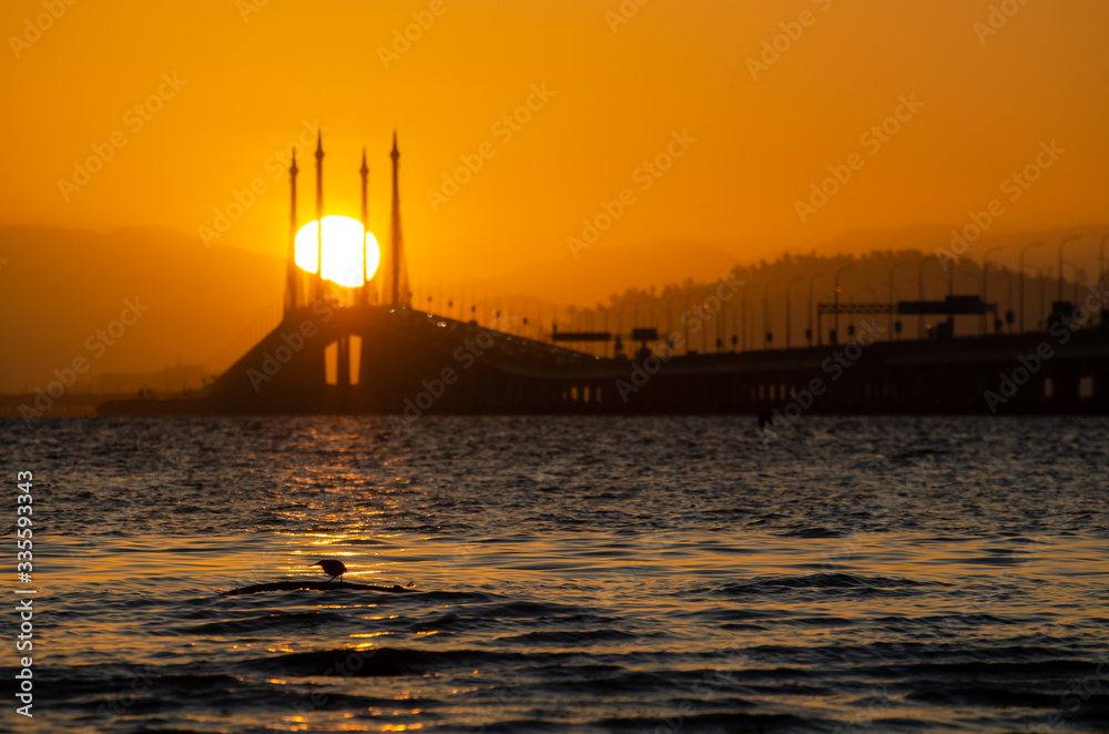 Naklejka premium Egg yolk sun trapped in cable stayed Penang Bridge.