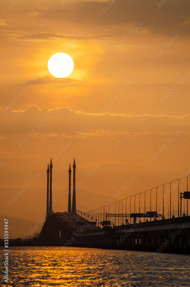 Obraz premium Silhouette sun at the top of mid span cable stayed bridge.