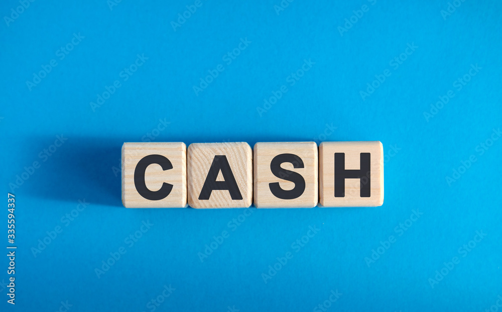 CASH text on wooden blocks, financial business concept, blue background CASH text on wooden blocks, financial business concept, blue background