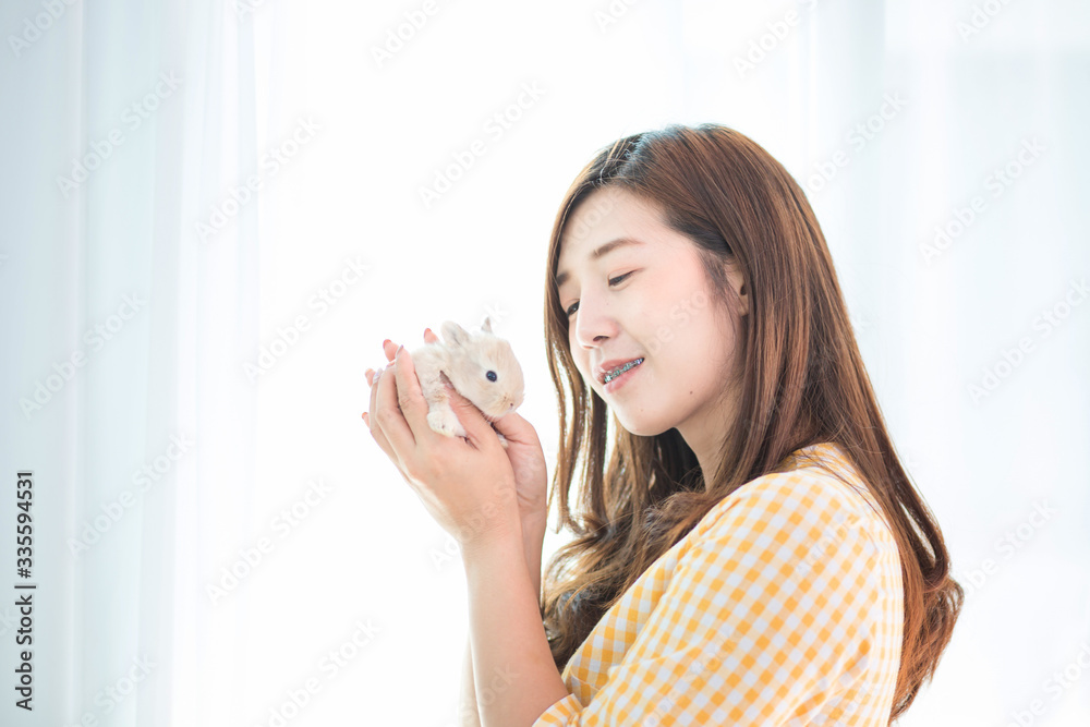 Women carrying a rabbit. Pretty young female holds cute little rabbit on white background. A young woman carrying a rabbit at Easter. Women carrying a rabbit. Pretty young female holds cute little rabbit on white background. A young woman carrying a rabbit at Easter.
