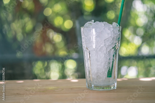 Glass of crushed ice with tube green