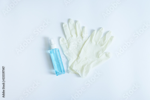 Medical gloves and sanitary alcohol spray on white background