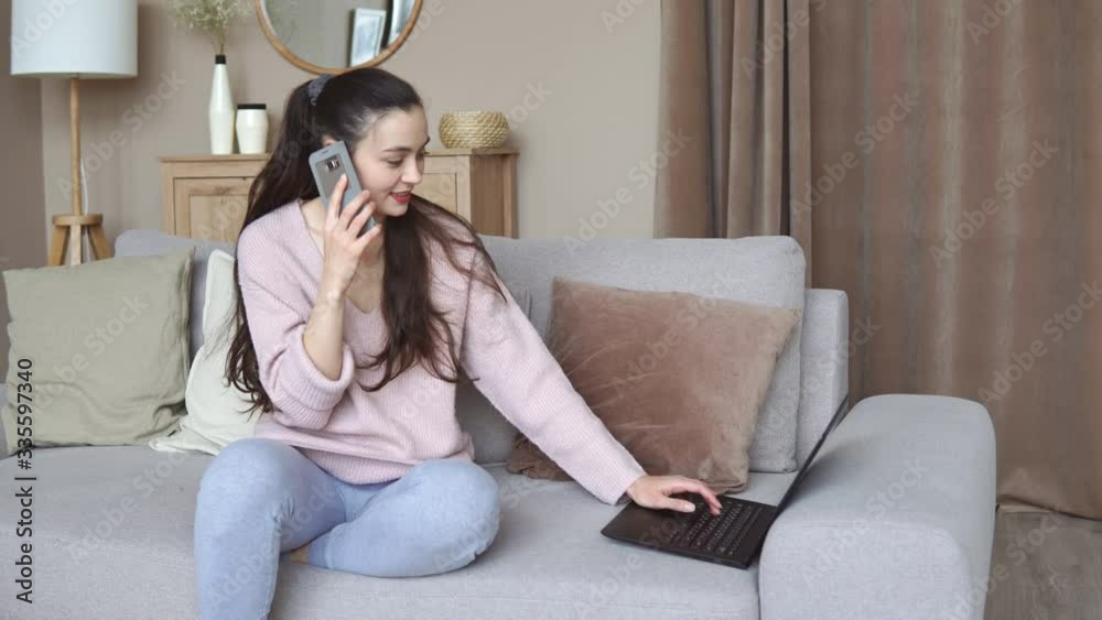 Casual young woman using laptop and smartphone on sofa, working from home Casual young woman using laptop and smartphone on sofa, working from home