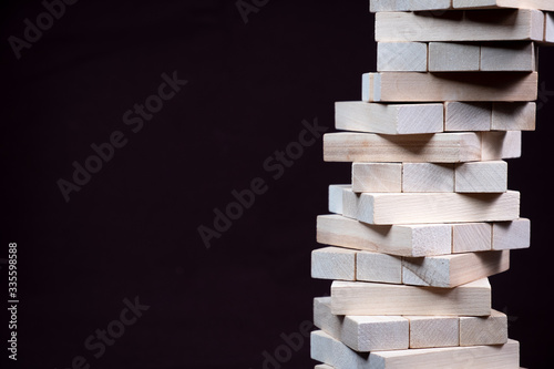 The tower is made of wooden blocks. Jenga Close up. On a brown background
