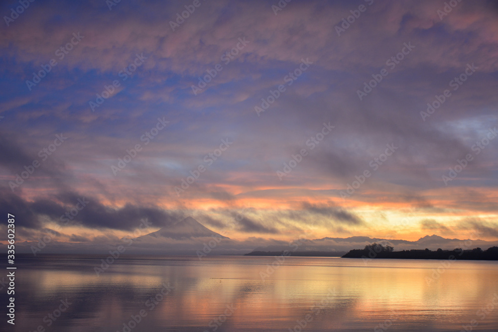 sunrise over lake with mountain in distance