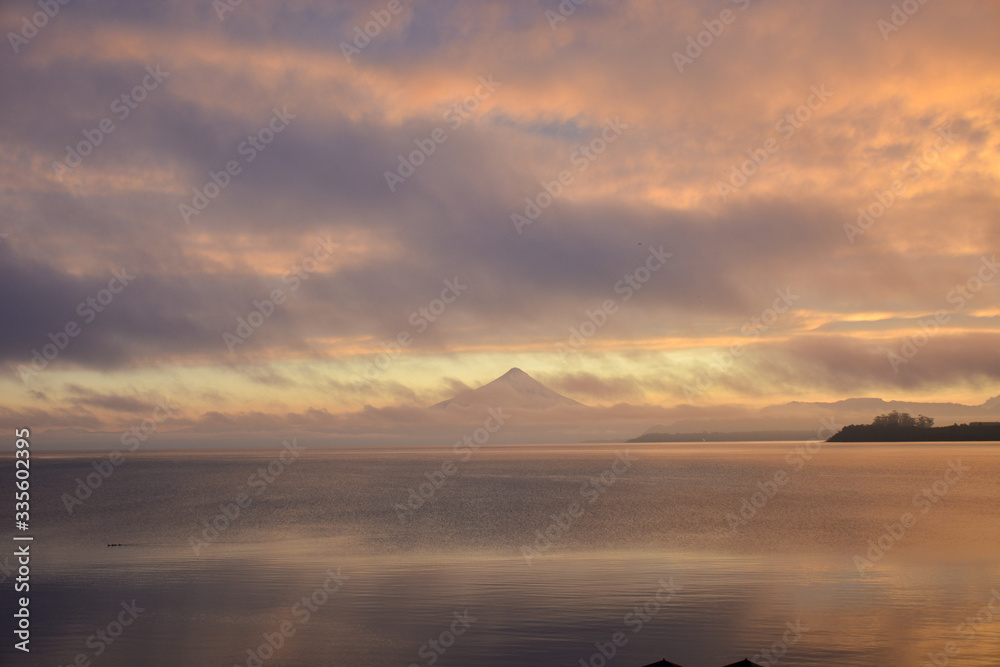 Sunrise sky over a lake with mountain in distance