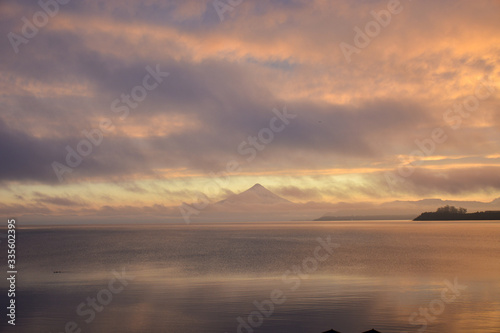 Sunrise sky over a lake with mountain in distance