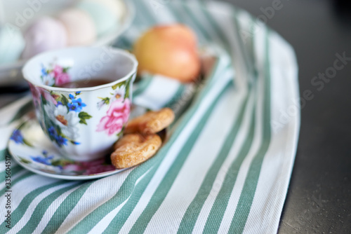 tea, marshmallows and cookies, an apple on a striped towel