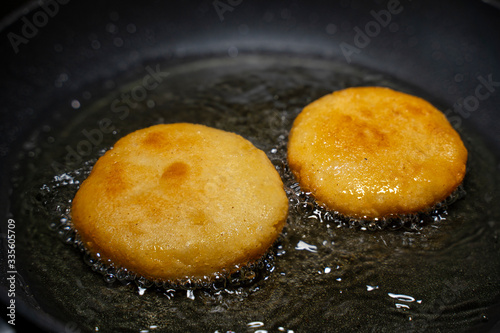 Arepas in a pan with oil. Close-up.