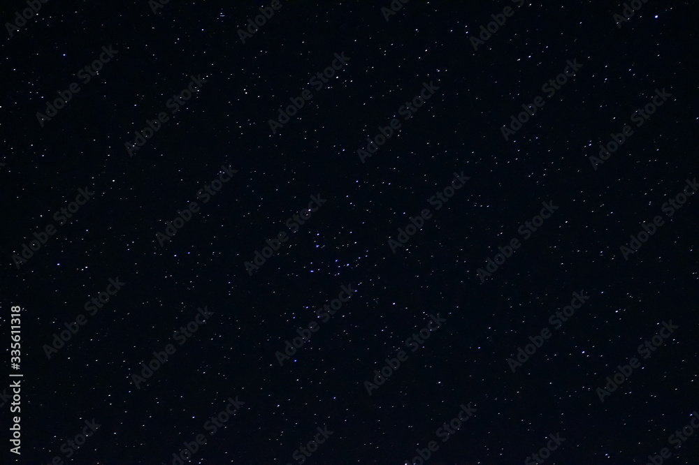 Fototapeta premium Long exposure night photo of a bright stars. A lot of stars with constellations. Far from the city. Night landscape.