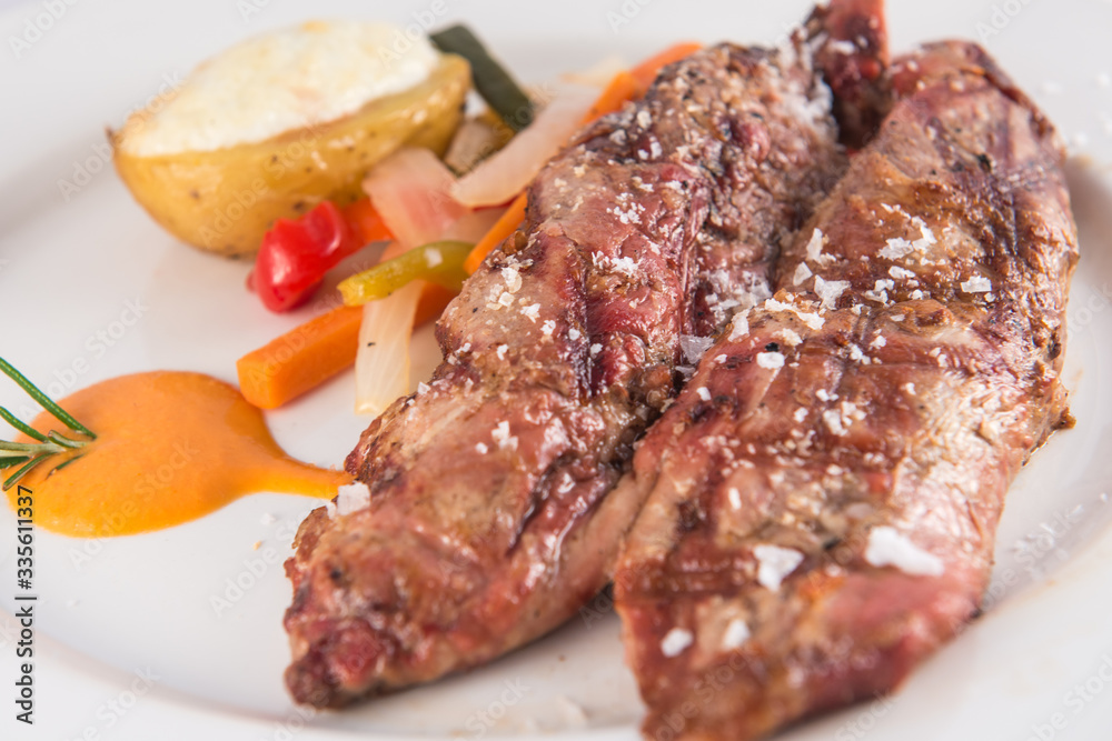 Grilled pork tenderloin with baked potato and vegetables.