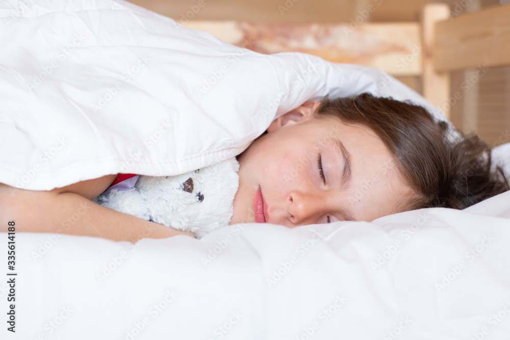 Portrait of a beautiful sleeping girl child in early morning with teddy bear under the white blanket. Sweet morning dream Portrait of a beautiful sleeping girl child in early morning with teddy bear under the white blanket. Sweet morning dream