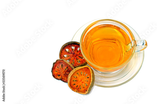 Top view bael fruit juice herbal drink surrounded by pieces of dried bael fruit isolate on white background. photo