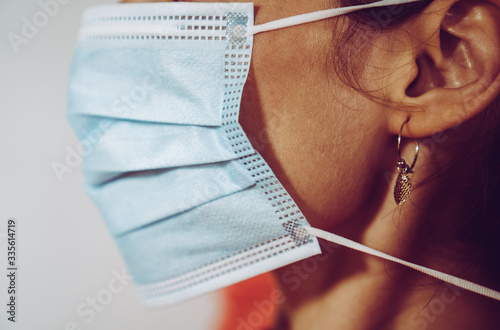 Girl putting on a surgical mask photo