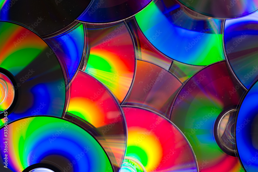 Group of old CD DVD compact optical disk storage medium with dust and scratches. Rainbow spectrum of iridescent colors Group of old CD DVD compact optical disk storage medium with dust and scratches. Rainbow spectrum of iridescent colors