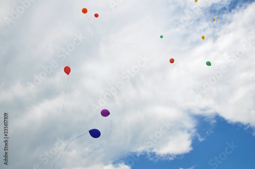 Balloons in the sky against a background of white clouds and blue sky