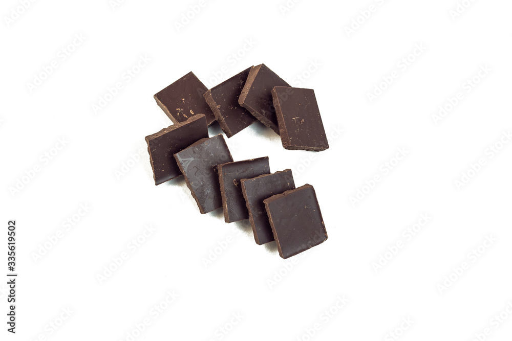 squares of dark chocolate stand behind each other forming the shape of a hook squares of dark chocolate stand behind each other forming the shape of a hook