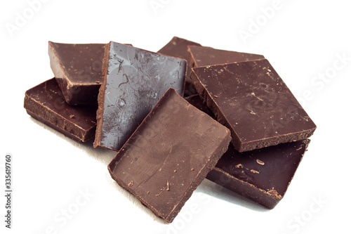 squares of dark brown chocolate are scattered on top of each other