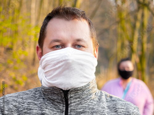 Keeping social distance while walking outside during coronavirus quarantine in homemade face masks photo