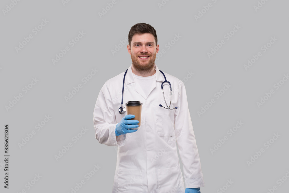 Doctor Showing Coffe To go Cup Wearing Gloves and Smiling Isolated Doctor Showing Coffe To go Cup Wearing Gloves and Smiling Isolated
