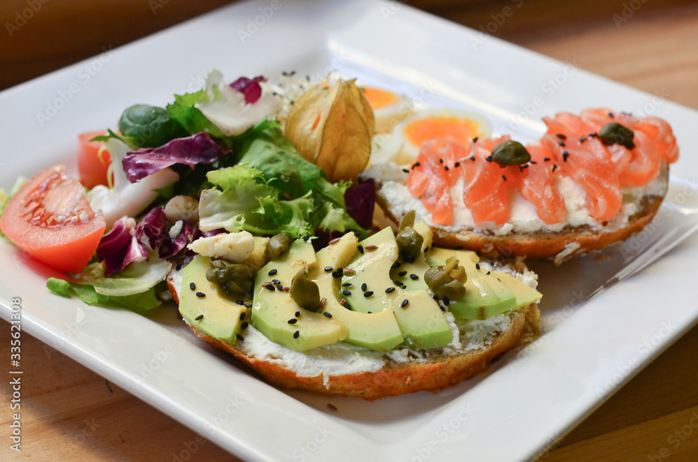 food, fried eggs with toast and mousse and salmon and avocados on a plate