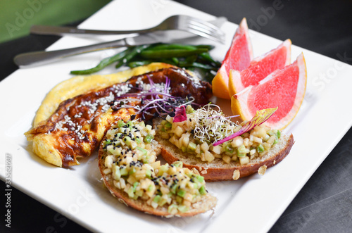 food, eggs with toast and avocado mousse and grapefruit on a plate photo