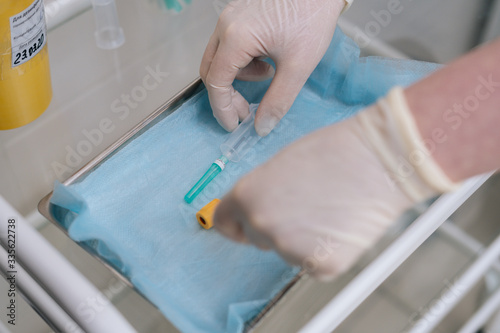 Close-up of nurse wearing medical gloves takes syringe for drawing blood. Preparation for medical procedures. View from above. Concept of healthcare and medicine. Concept of healthcare and medicine.
