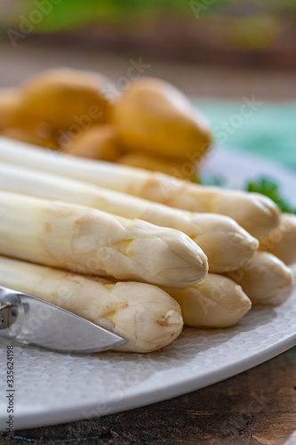 Ingredients for spring vegetarian dinner, high quality Dutch white asparagus, washed and peeled on board, ready to cookand and young potatoes