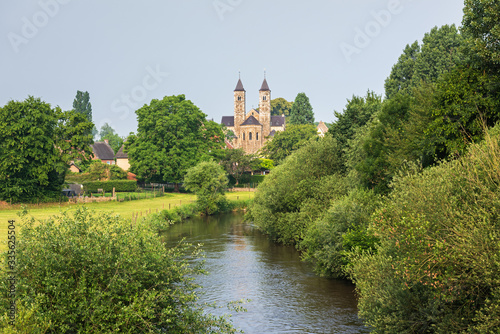 Beautiful view of the Romanesque basilica in Sint Odiliënberg village from the bidge over river Roer, Limburg, The Netherlands
