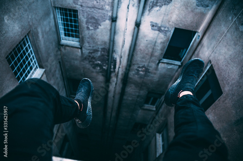 Legs hanging over a building