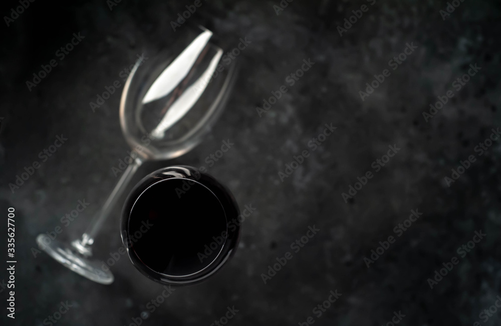 Wine glasses with red wine on stone background with copy space for your text.