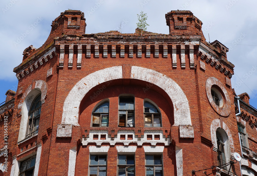 Close-up view of the facade of an old red brick building in the modernist style, late 19th century. Historical architectural and industrial complex 