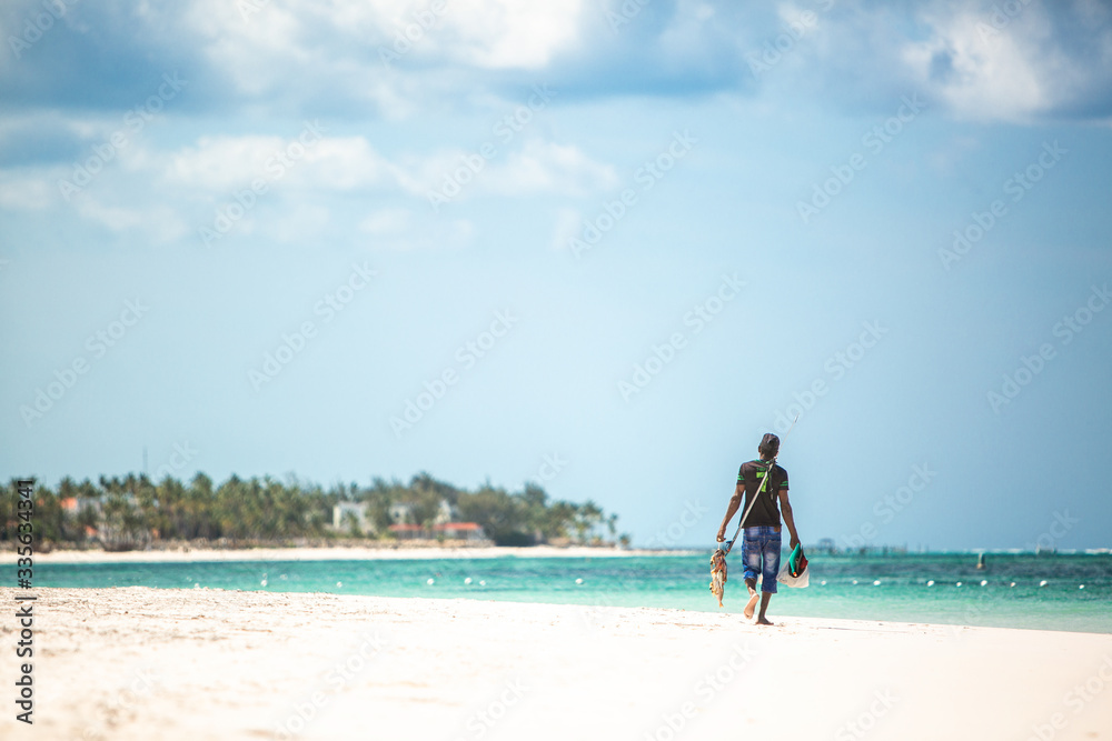 A fisherman sells fresh fish on a tropical beach. The life of the local population on the islands of the Atlantic Ocean. Dominican Republic